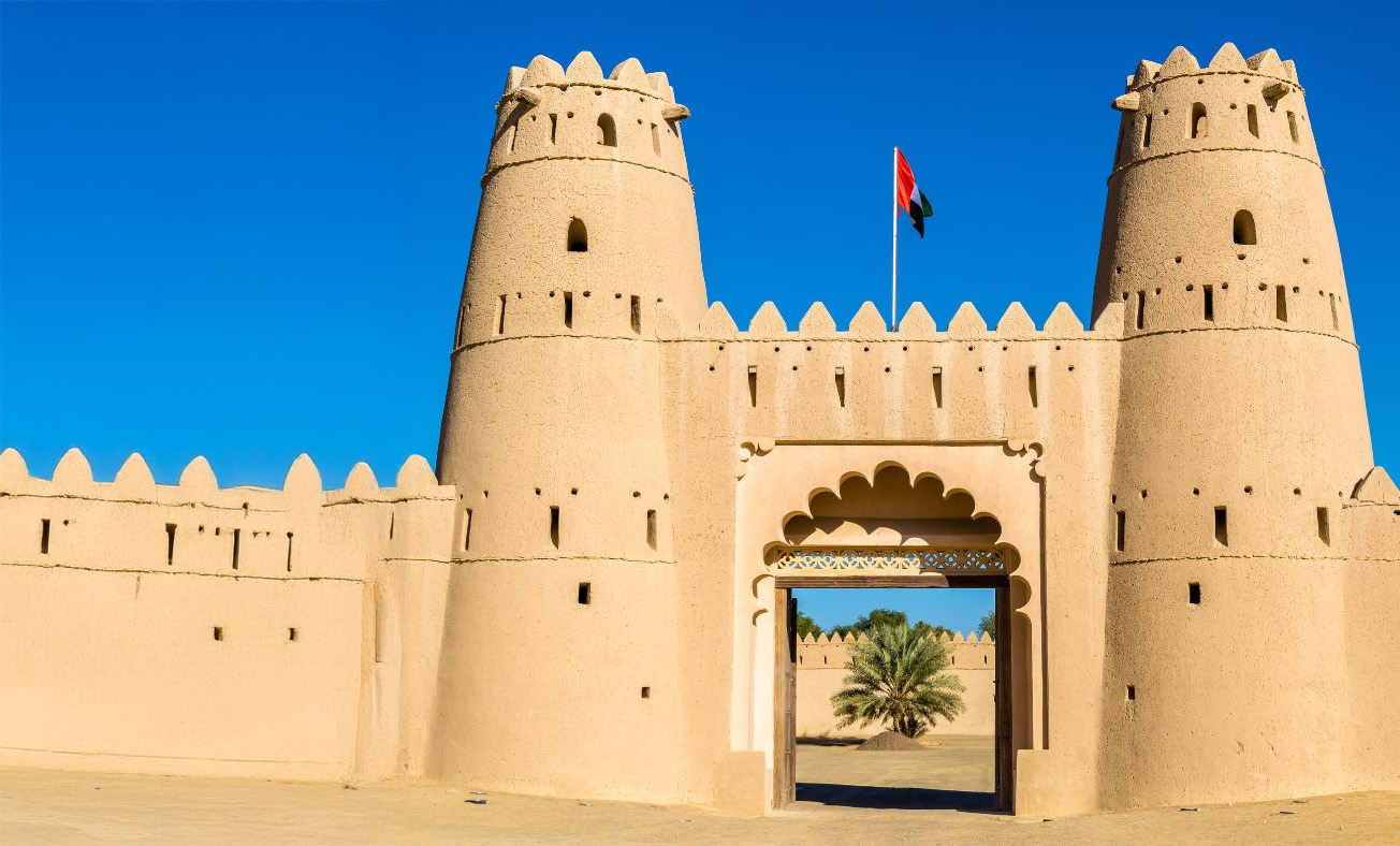 Traditional Emirati architecture against a modern city skyline.